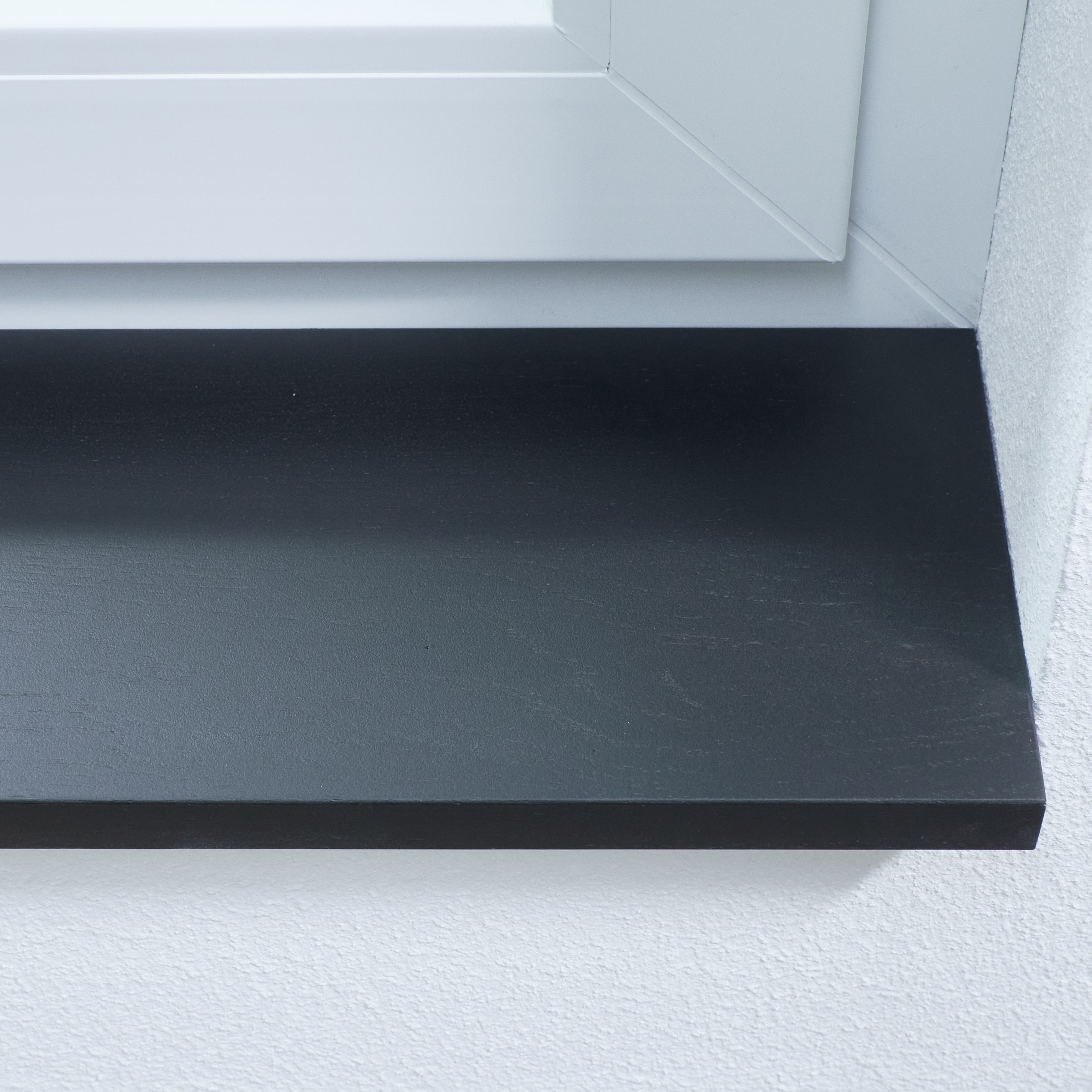 Davanzale in rovere selvatico tinto nero, con giunzioni a pettine, primo piano del bordo anteriore nella spalletta bianca