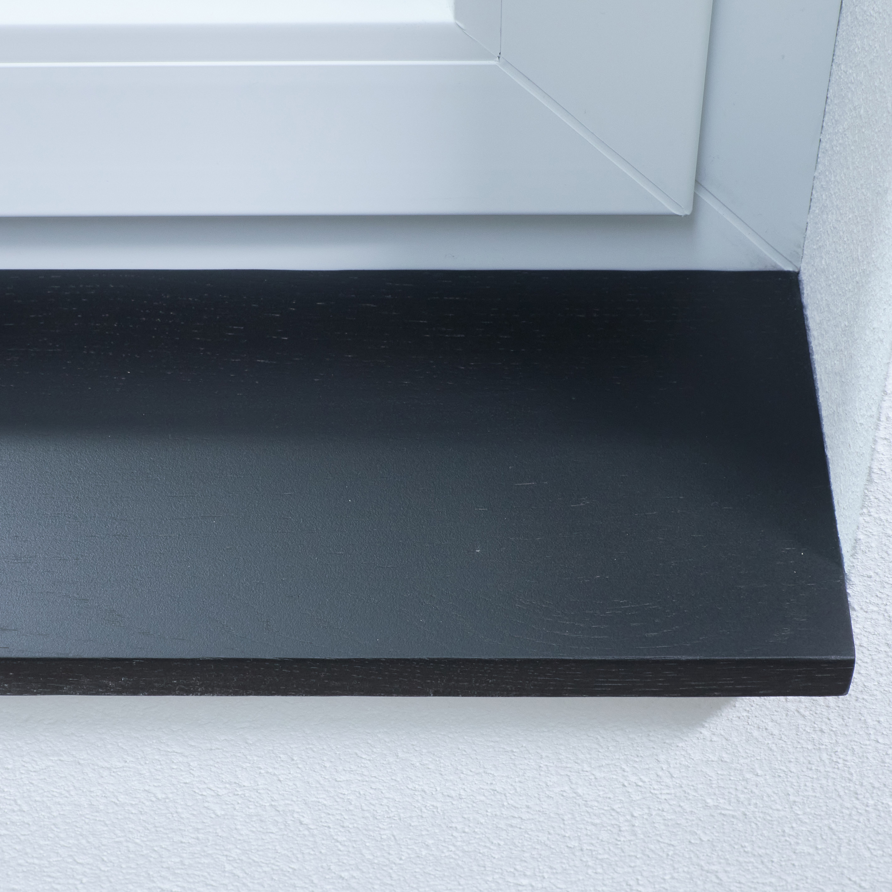 Davanzale in rovere tinto nero, primo piano del bordo anteriore con leggera struttura del legno in spalletta bianca