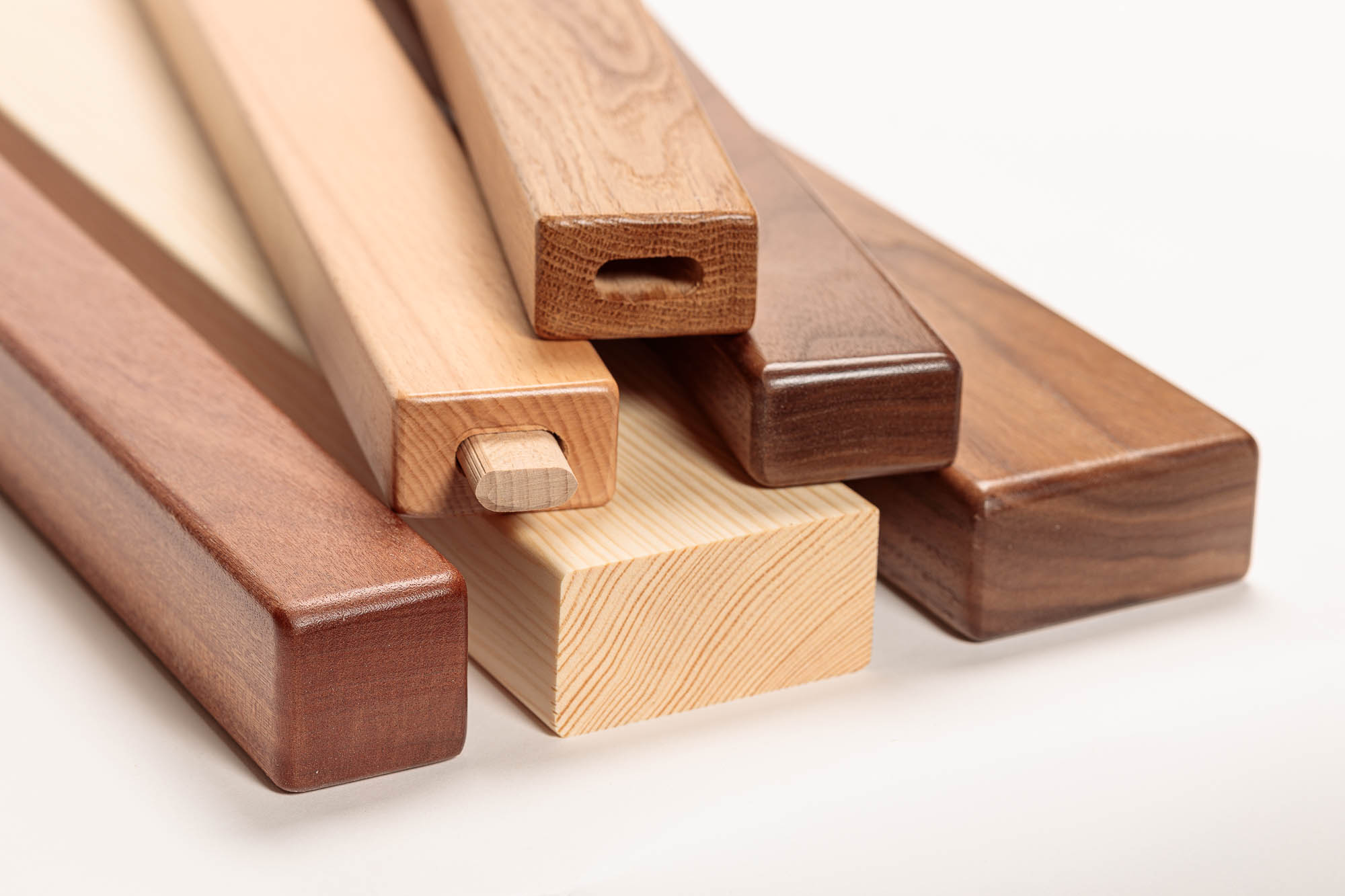 Corrimano in legno rettangolari in diverse essenze impilati, un profilo con raccordo in legno, primo piano delle estremità