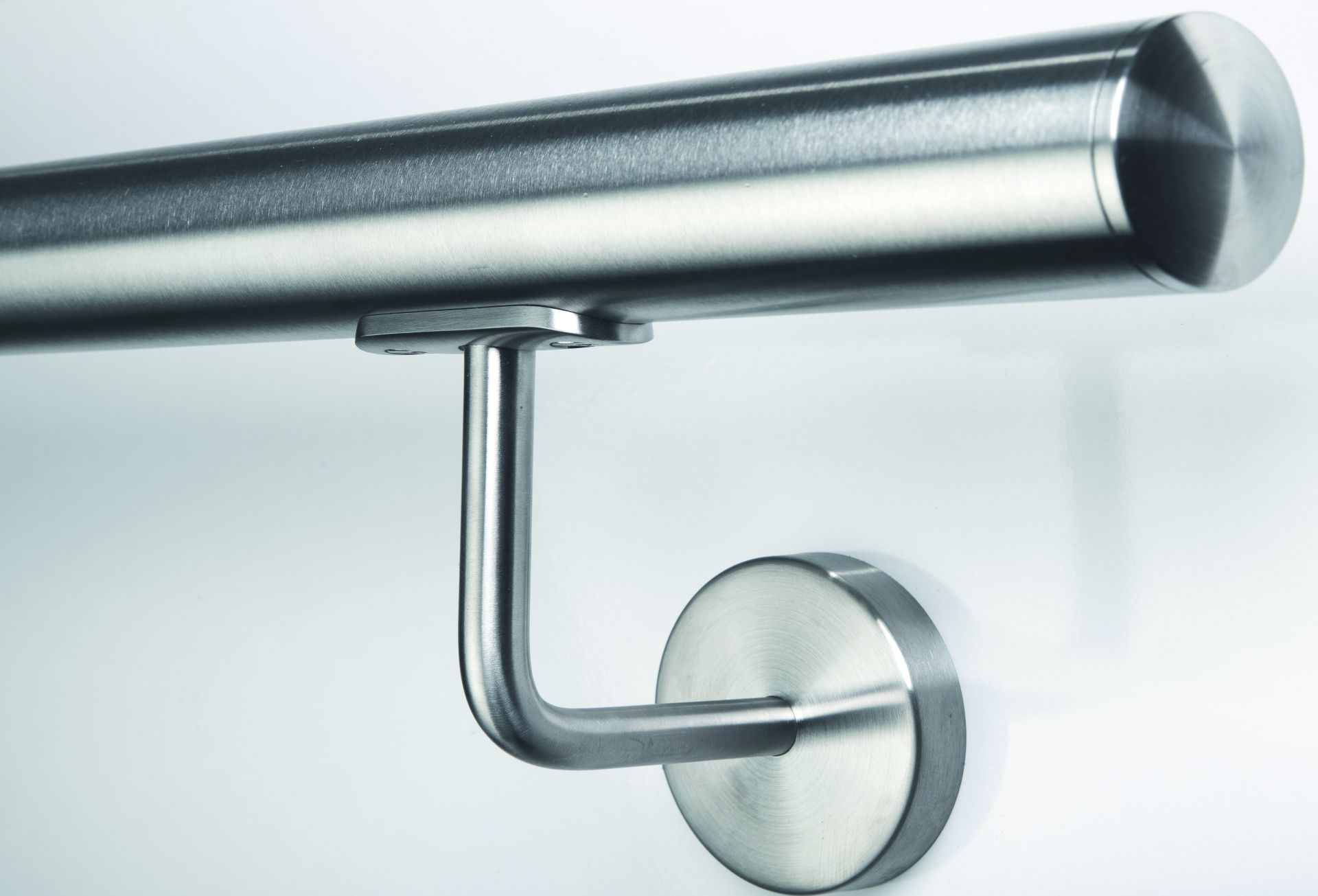 Corrimano rotondo in acciaio inox con tappo terminale piatto e supporto a parete inox, vista laterale su sfondo chiaro