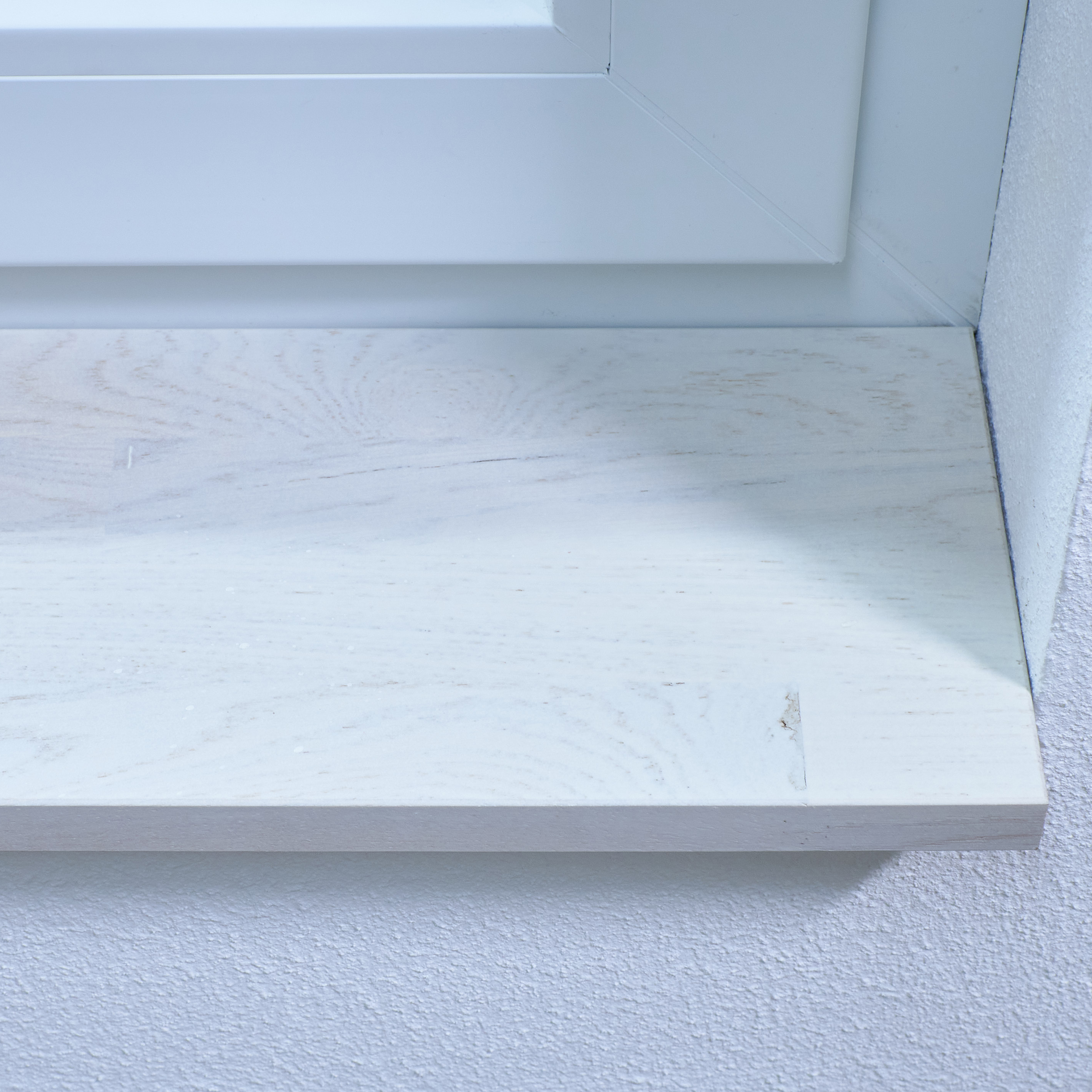 Davanzale in rovere selvatico tinto bianco, con giunzioni a pettine, primo piano del bordo con venatura e piccolo nodo