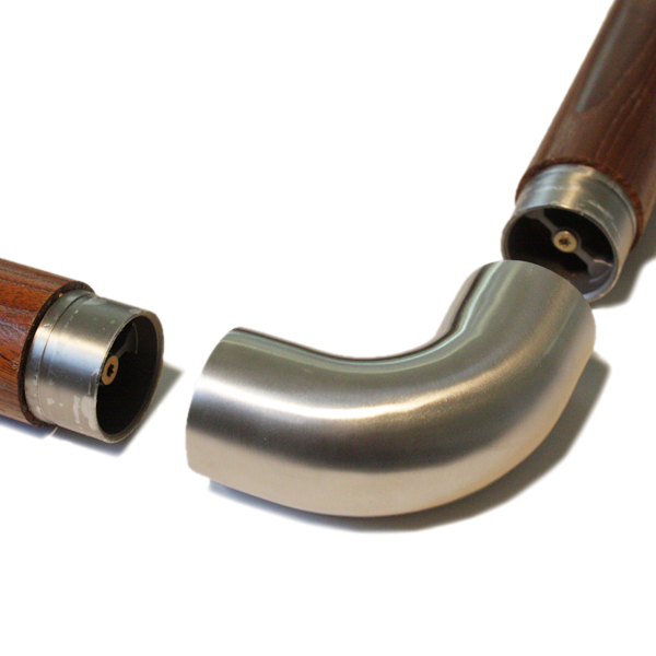 Curva a 90° in acciaio inossidabile tra due corrimano rotondi in legno con raccordi inox, prima dell'innesto